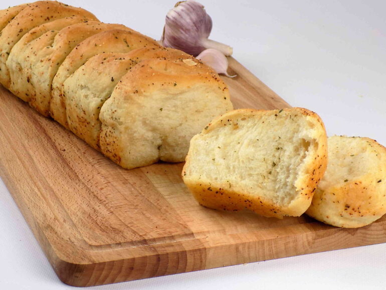 Zdjęcie przedstawiające rwany chlebek czosnkowy według przepisu https://kuchnianawypasie.pl/